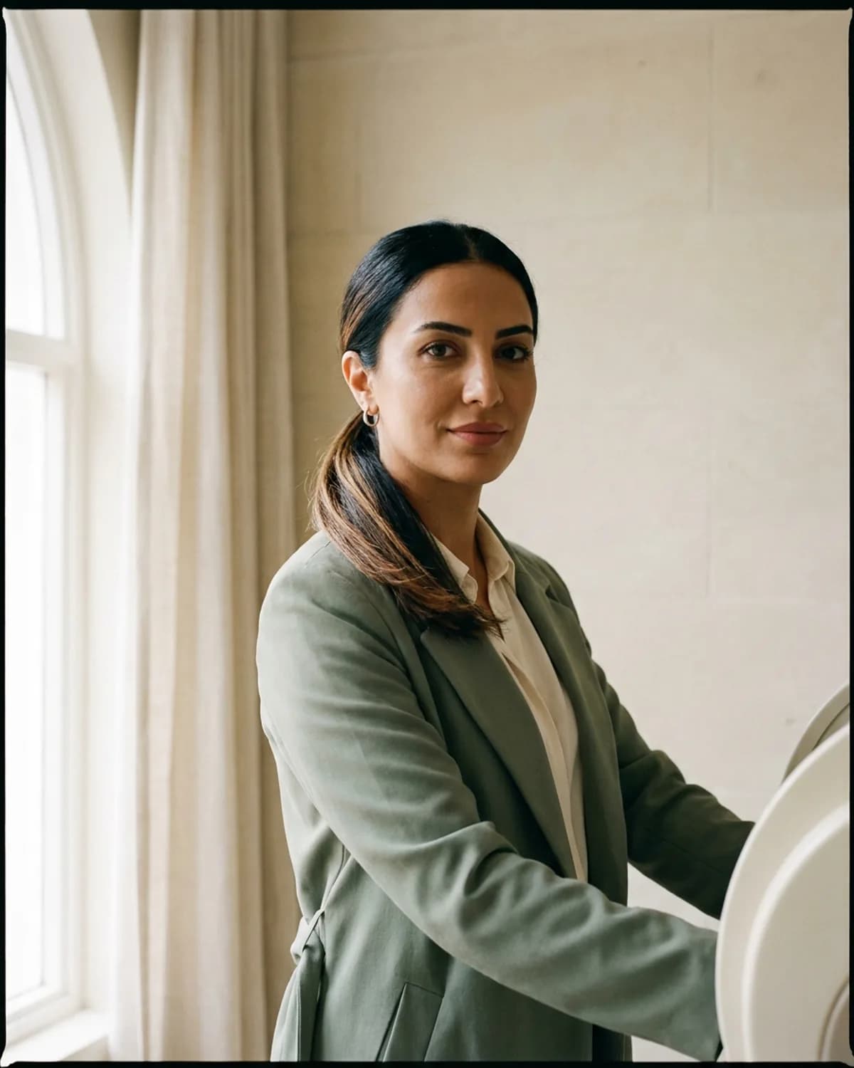 Ezgi Kaplan, lazer teknisyeni, 5 yıl deneyim, sage atelier coat, sleek low ponytail, silver hoop earring