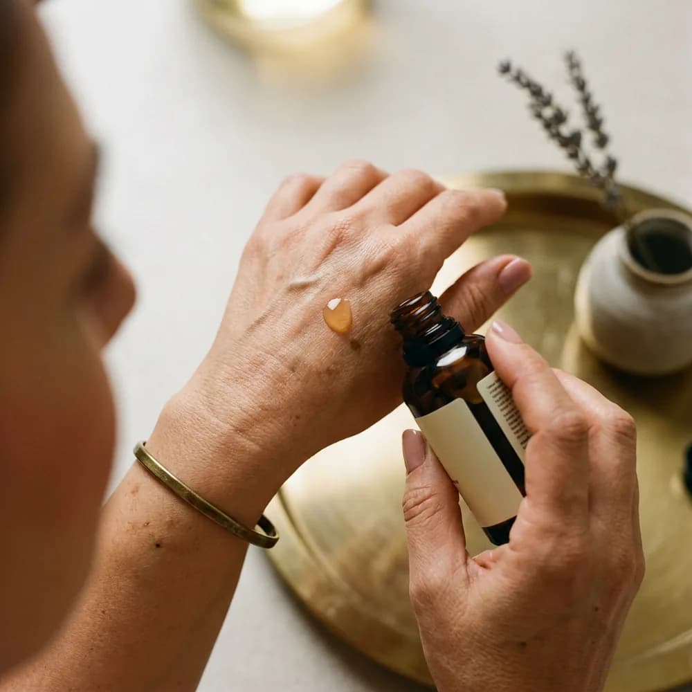 Anti-aging ritüel, apothecary serum dropper, mature 45 yaş el, dignified aging